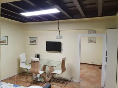a dining room with a table and chairs and a tv at Campo Marzio Exclusive Maison in Rome