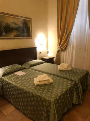 a hotel room with two towels on a bed at Bye Rome Guesthouse in Rome