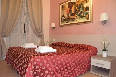 a tree with a pink flower on a street at Bye Rome Guesthouse in Rome