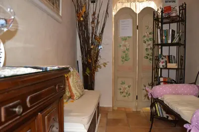 a hotel room with a bed and a vase of flowers at Bye Rome Guesthouse in Rome