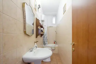 a bathroom with a sink and a toilet and a mirror at Trastevere classico self check in in Rome
