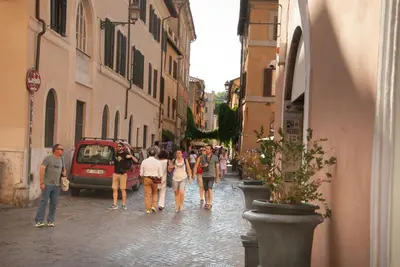 a group of people walking down a street at Trastevere classico self check in in Rome