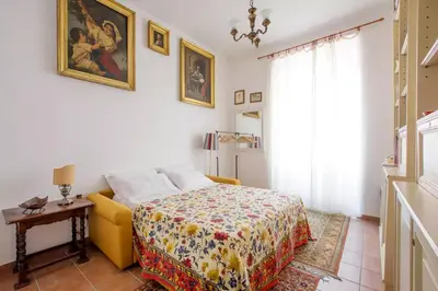 a bedroom with a bed and a yellow couch at Trastevere classico self check in in Rome