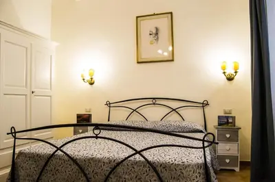 a bedroom with a bed and two lights on the wall at B&B Domus Piazza del Popolo in Rome
