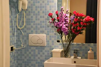a bathroom with a vase of flowers on the sink at B&B Domus Piazza del Popolo in Rome
