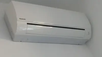a white microwave oven hanging from a ceiling at T C RMs in Rome