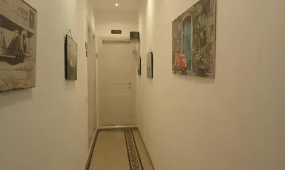 a hallway with paintings on the wall and a door at T C RMs in Rome