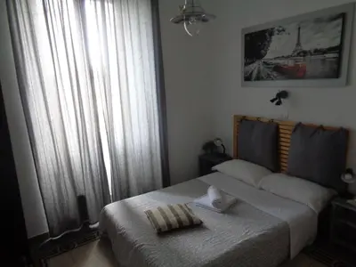 a bedroom with a bed and a large window at T C RMs in Rome