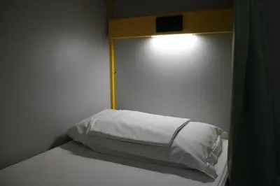 a bed with a white pillow and a light on it at Roma Scout Center in Rome