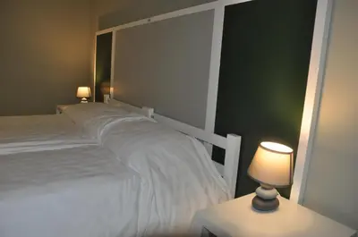 a bedroom with a white bed and two lamps at Roma Scout Center in Rome