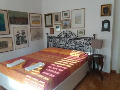 a bed in a bedroom with pictures on the wall at Priscilla's inn in Rome