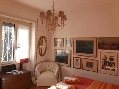 a living room with a chair and pictures on the wall at Priscilla's inn in Rome