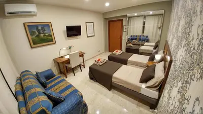 a hotel room with two beds and a couch at Vatican69 New Apartment in Rome