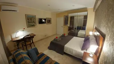 a hotel room with a bed and a desk and chairs at Vatican69 New Apartment in Rome