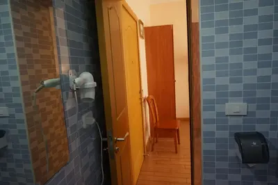 a bathroom with blue tiled walls and a door at Hotel Filippo in Rome
