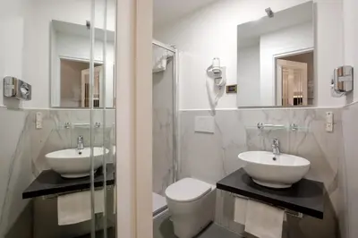 a bathroom with two sinks and a toilet and mirror at Hotel Oxford in Rome