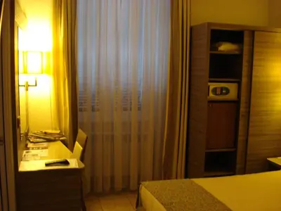 a hotel room with a bed and a desk with a lamp at Morrisson Exclusive Rooms in Rome