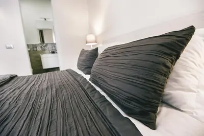 a bed with black pillows on it in a bedroom at Angolo di Roma Guest house in Rome