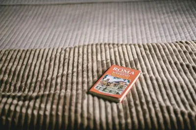 a book sitting on top of a bed at Angolo di Roma Guest house in Rome
