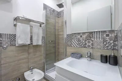 a white bathroom with a sink and a shower at Angolo di Roma Guest house in Rome