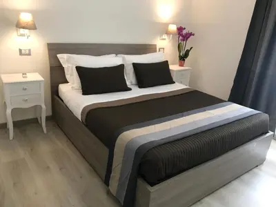 a bedroom with a large bed with two night stands at Angolo di Roma Guest house in Rome