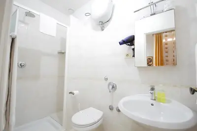 a white bathroom with a sink and a toilet at Hotel Alexis in Rome