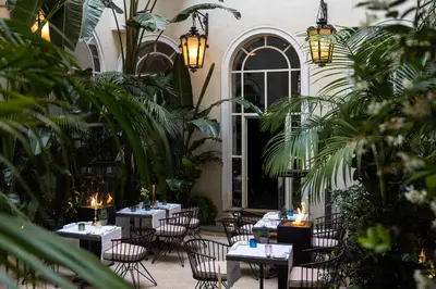 a courtyard with tables and chairs and plants at Hotel Vilòn - Small Luxury Hotels of the World in Rome