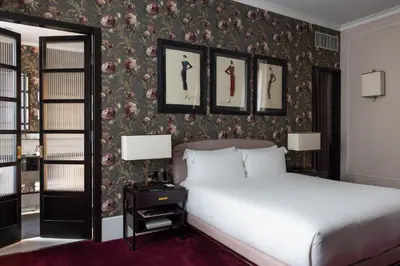 a bedroom with a bed and some pictures on the wall at Hotel Vilòn - Small Luxury Hotels of the World in Rome