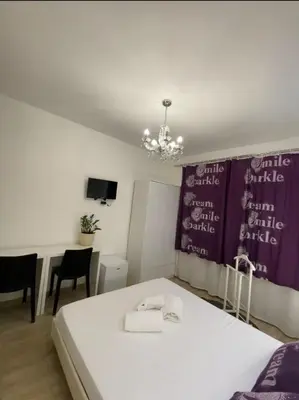 a bedroom with a bed and a table and a chandelier at Rome Sweet Home Vatican in Rome