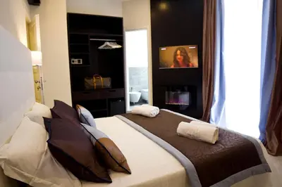 a bedroom with a large bed with two pillows on it at Roman Holidays Boutique Hotel in Rome