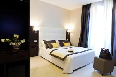 a bedroom with a large white bed with yellow pillows at Roman Holidays Boutique Hotel in Rome