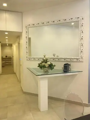 a mirror on a wall with a table with flowers on it at Roman Holidays Boutique Hotel in Rome