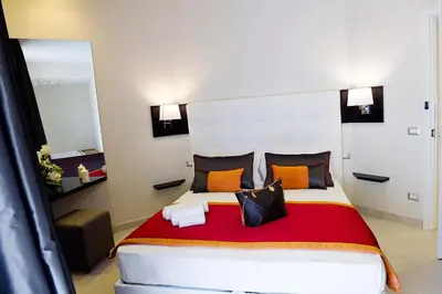a bedroom with a large bed with orange and black pillows at Roman Holidays Boutique Hotel in Rome