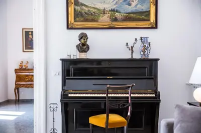 a black piano in a living room with a chair at Domus Aurea 295 in Rome