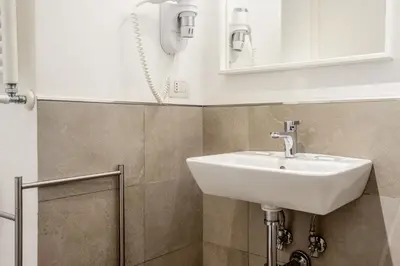 a bathroom with a sink and a mirror at Rome Vatican Rooms in Rome