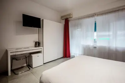 a bedroom with a bed and a desk and a television at Rome Vatican Rooms in Rome