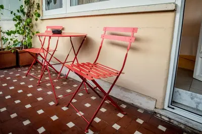 a red chair and a table next to a building at Rome Vatican Rooms in Rome