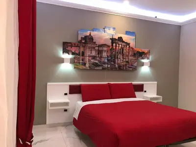 a bedroom with a red bed and a painting on the wall at Ann Inn in Rome