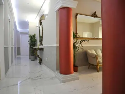 a red column in a room with a table and a mirror at Ann Inn in Rome