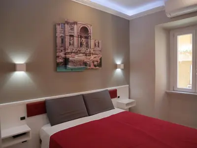 a bedroom with a red bed and a painting on the wall at Ann Inn in Rome