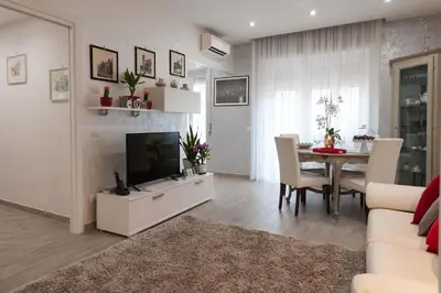 a living room with a television and a dining room table at M&M House in Rome