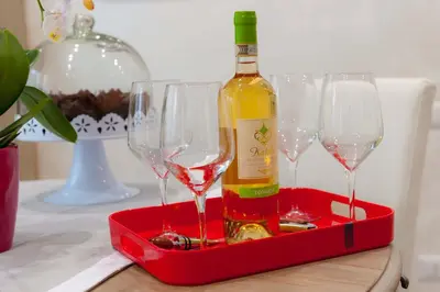 a bottle of wine in a red tray with wine glasses at M&M House in Rome