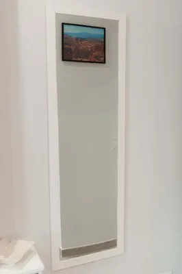 a mirror in a white wall with a picture on it at M&M House in Rome