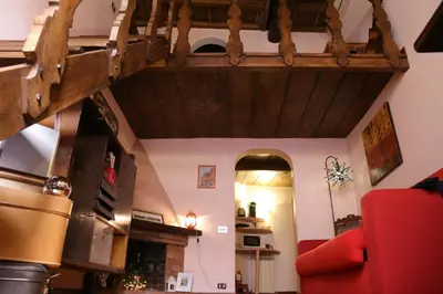 a living room with a red couch and a wooden staircase at Un Tetto al Pantheon in Rome