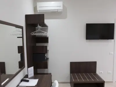a living room with a tv and a mirror at Venustas Roma Hotel in Rome