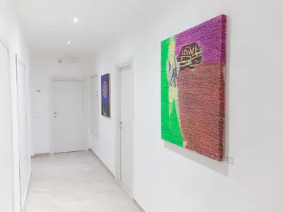 a hallway with a large painting on a wall at Venustas Roma Hotel in Rome