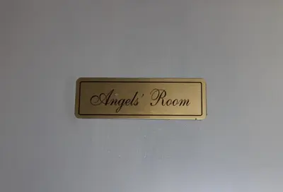 a metal sign that reads angel poem on a white wall at San Peter's Golden Rooms in Rome