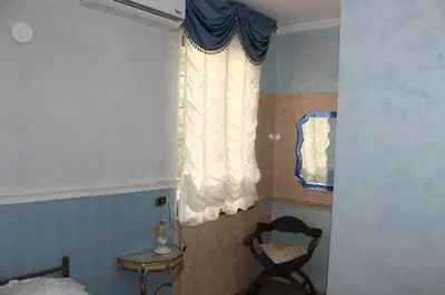 a bedroom with a window with a chair and a table at San Peter's Golden Rooms in Rome