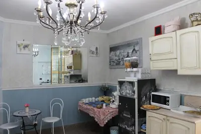 a kitchen with a small table and a chandelier at San Peter's Golden Rooms in Rome