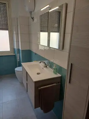 a bathroom with a sink and a mirror and a toilet at Double room da Giulio in Rome